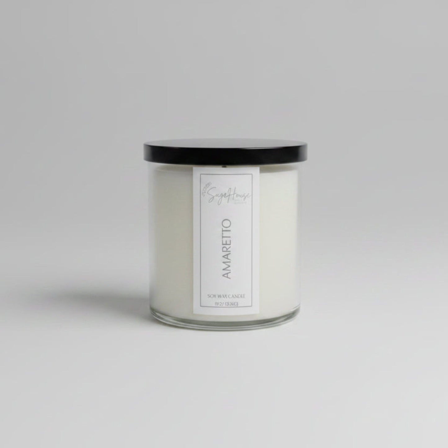 A white soy wax candle in a clear container, placed on a wooden surface, with a label on the front.