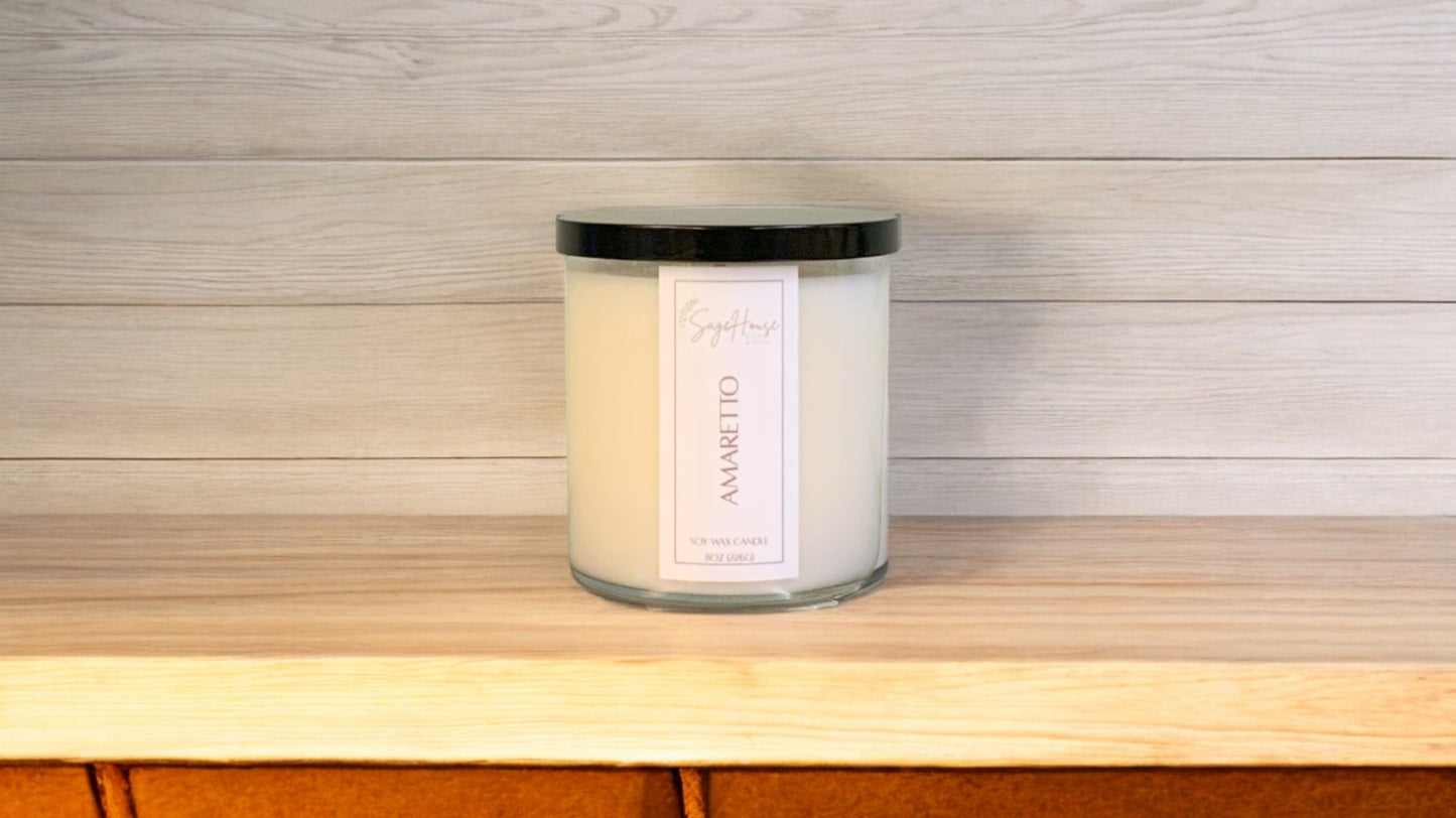 A white soy wax candle in a clear container, placed on a wooden surface, with a label on the front.