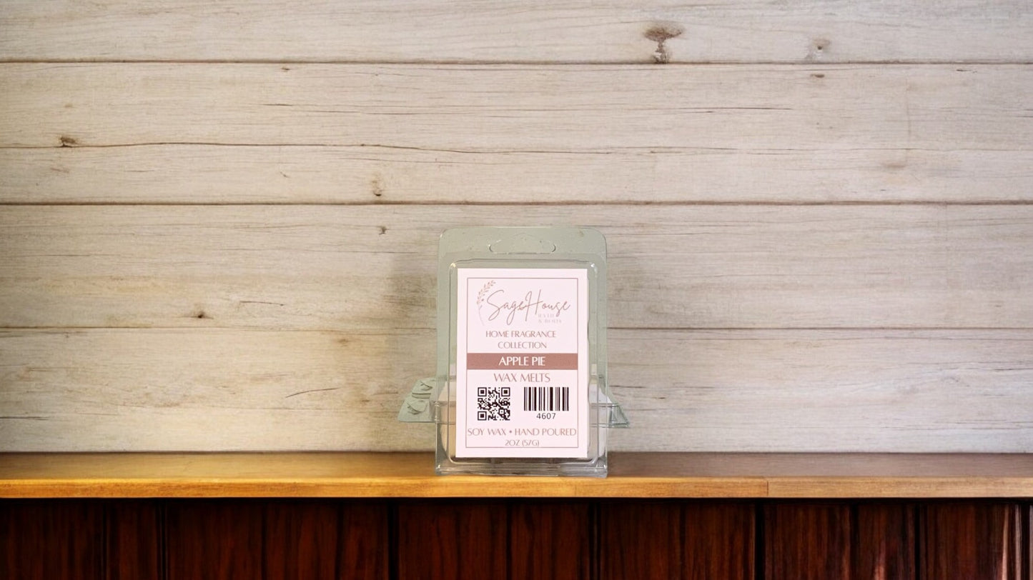 A clear clamshell container holding 6 wax melt cubes with a label on top, placed on a wooden surface against a wooden background.