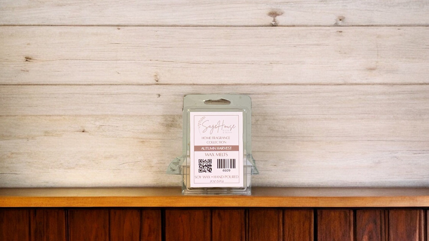 A clear clamshell container holding 6 wax melt cubes with a label on top, placed on a wooden surface against a wooden background.