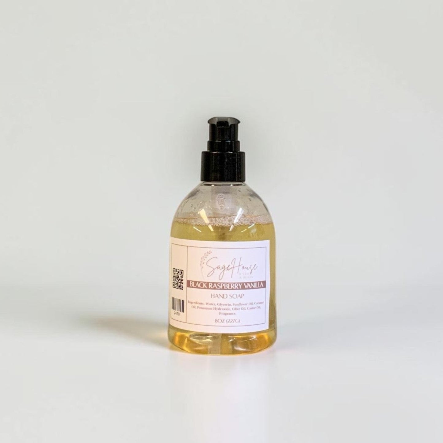 A bottle with black pump top and white label. On a white background.