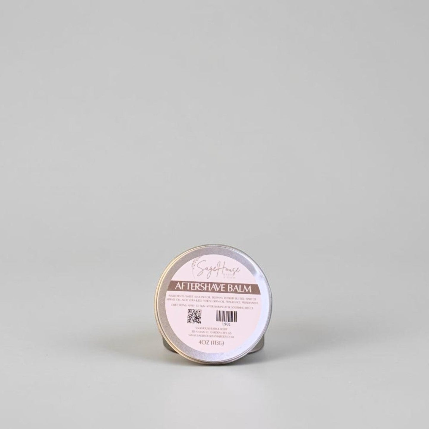 A round tin of balm, sits on a neutral light gray background.
