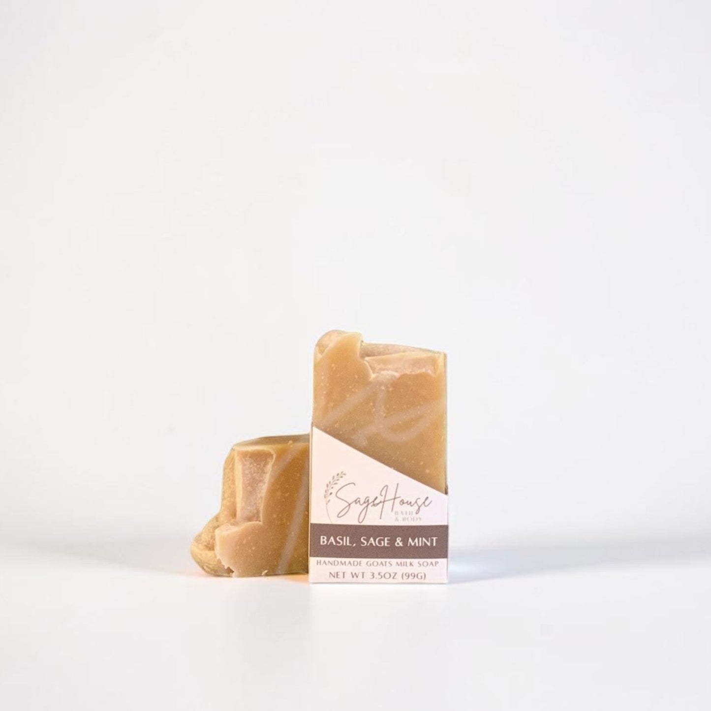 A labeled bar of soap sitting in front of a matching bar of soap. On a white background.