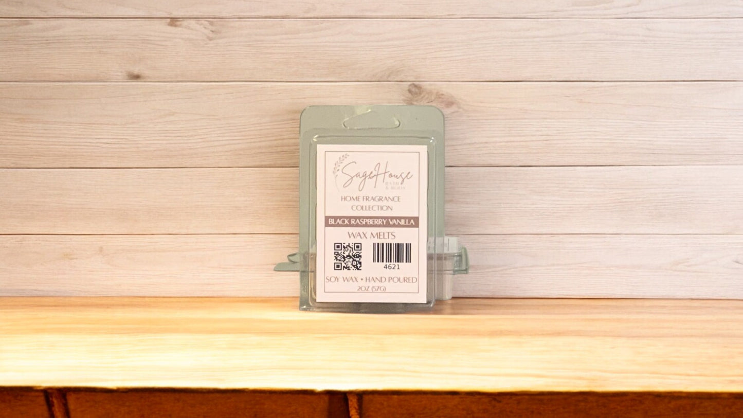 A clear clamshell container holding 6 wax melt cubes with a label on top, placed on a wooden surface against a wooden background.