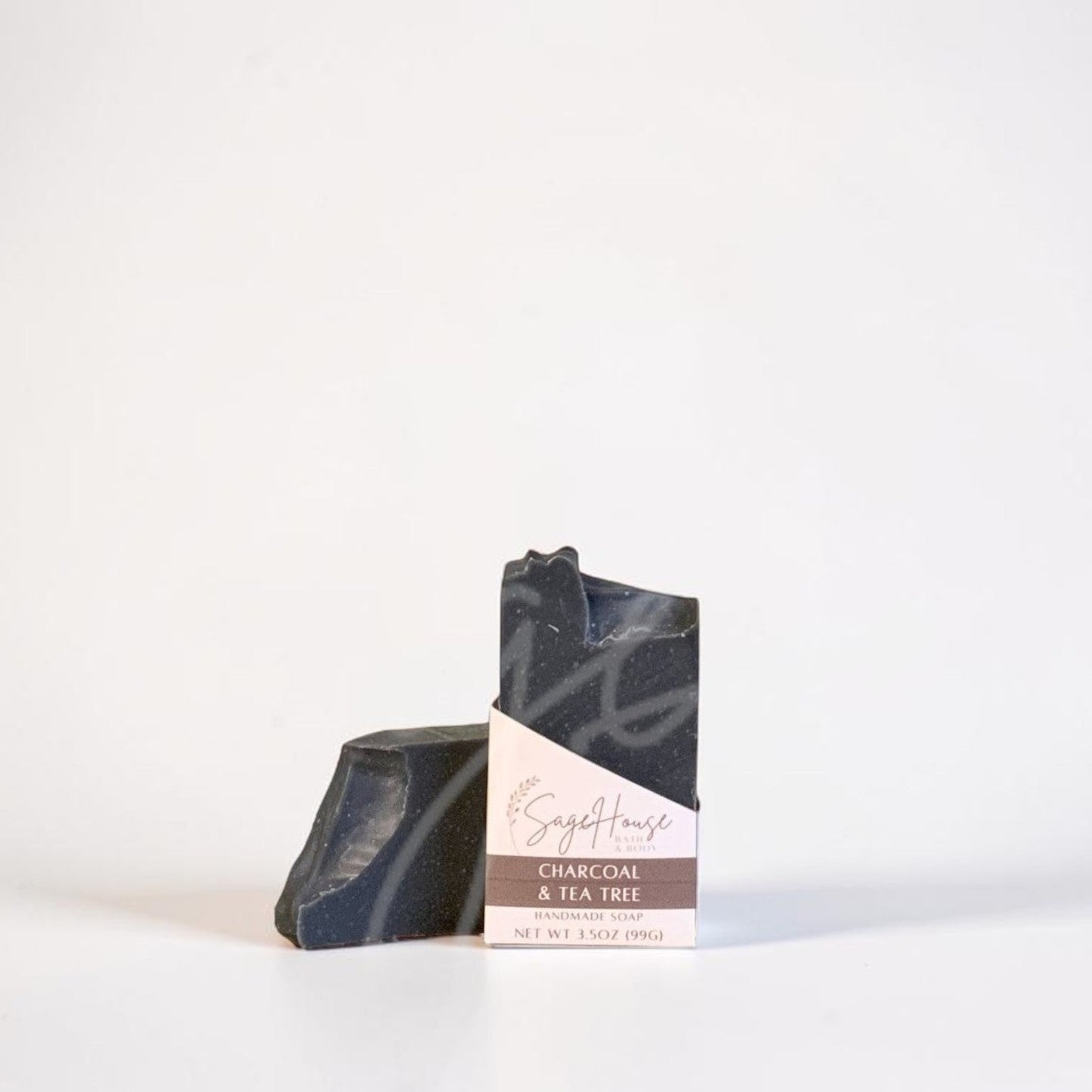A labeled bar of soap sitting in front of a matching bar of soap. On a white background.