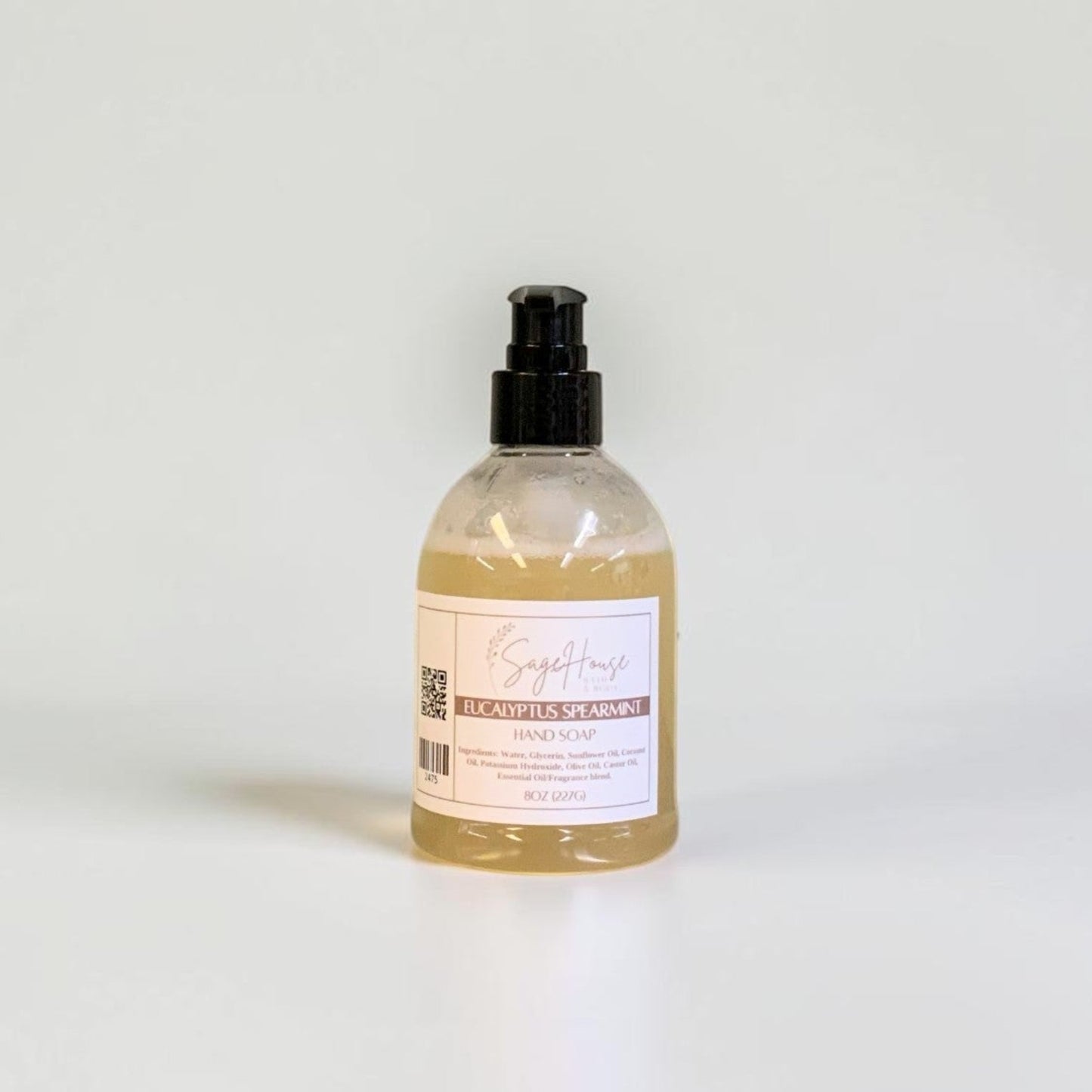A bottle with black pump top and white label. On a white background.