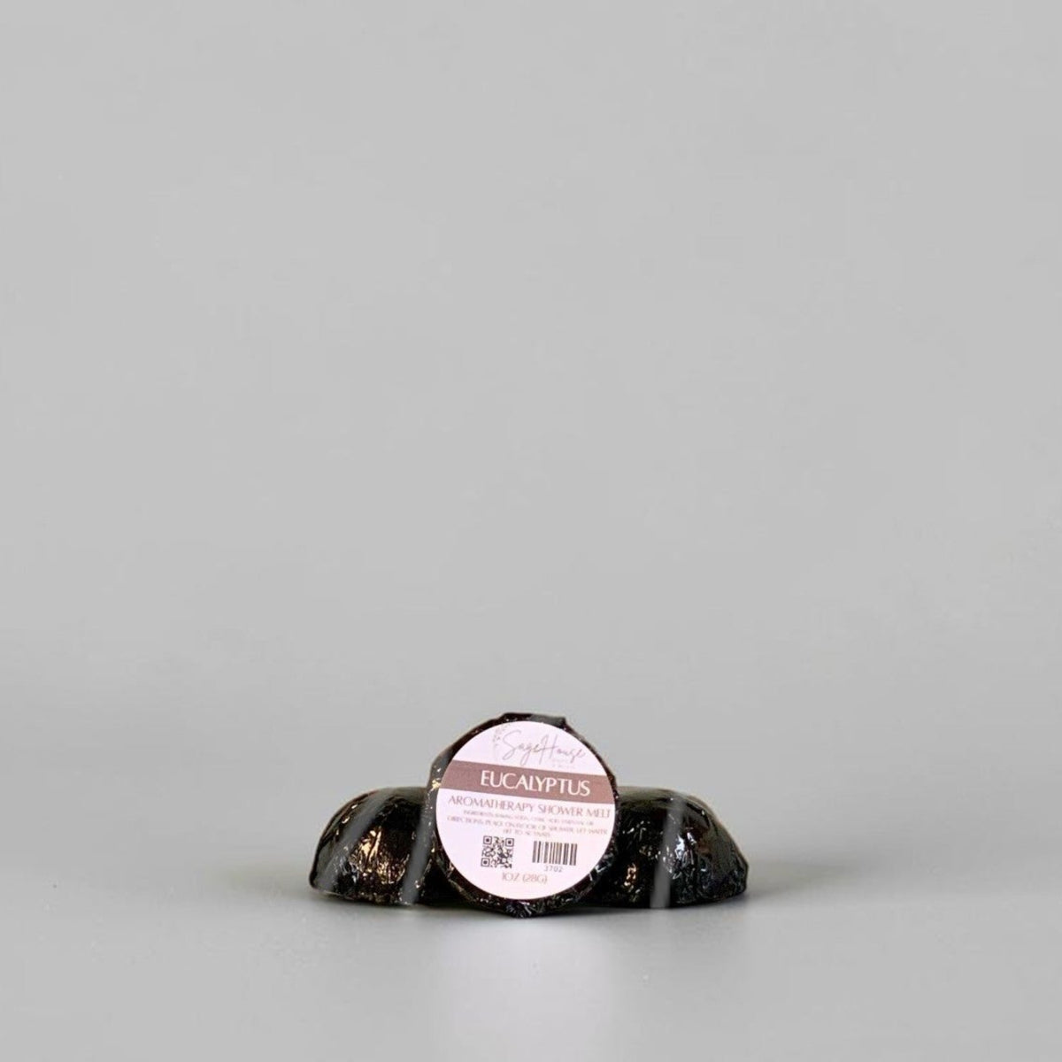 One labeled shower melt propped in front of 2 other shower melts. Sitting on a white background.