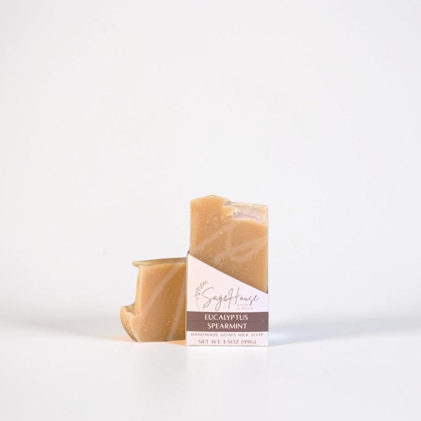 A labeled bar of soap sitting in front of a matching bar of soap. On a white background.