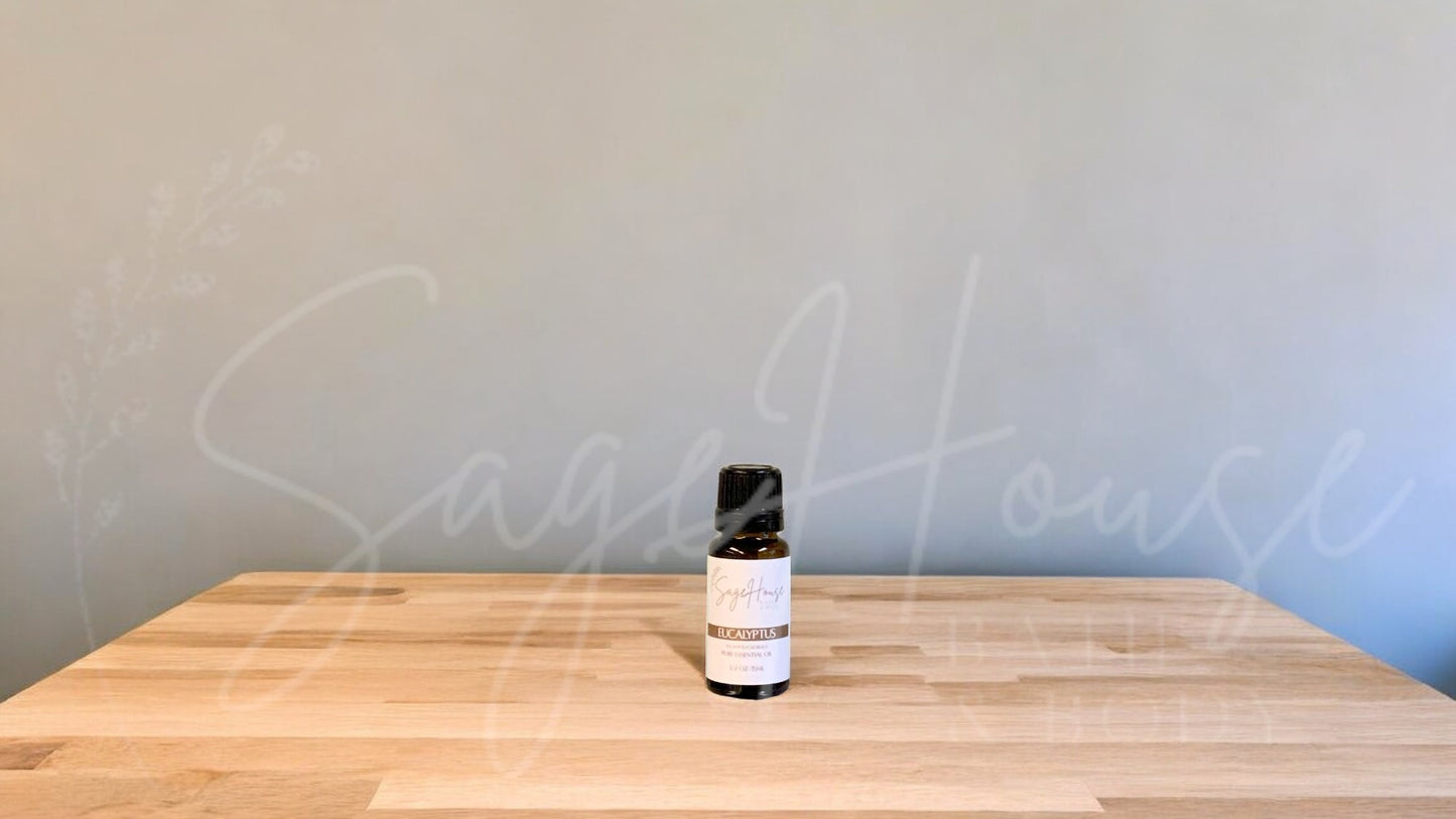 A small bottle of eucalyptus globulus essential oil is placed on a wooden surface with a plain background.