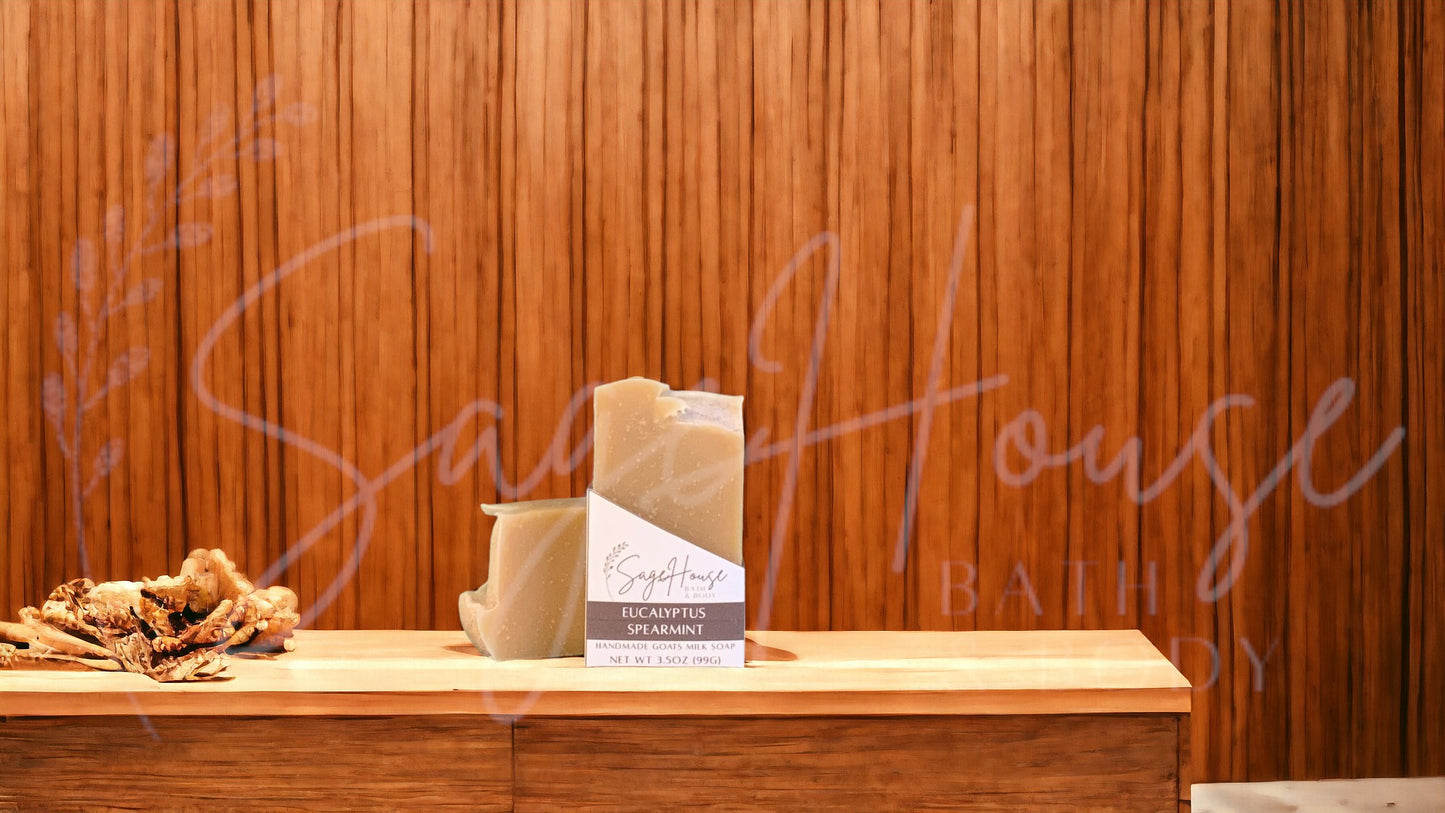 A tan bar of soap in a white labeled box, on a wood surface.