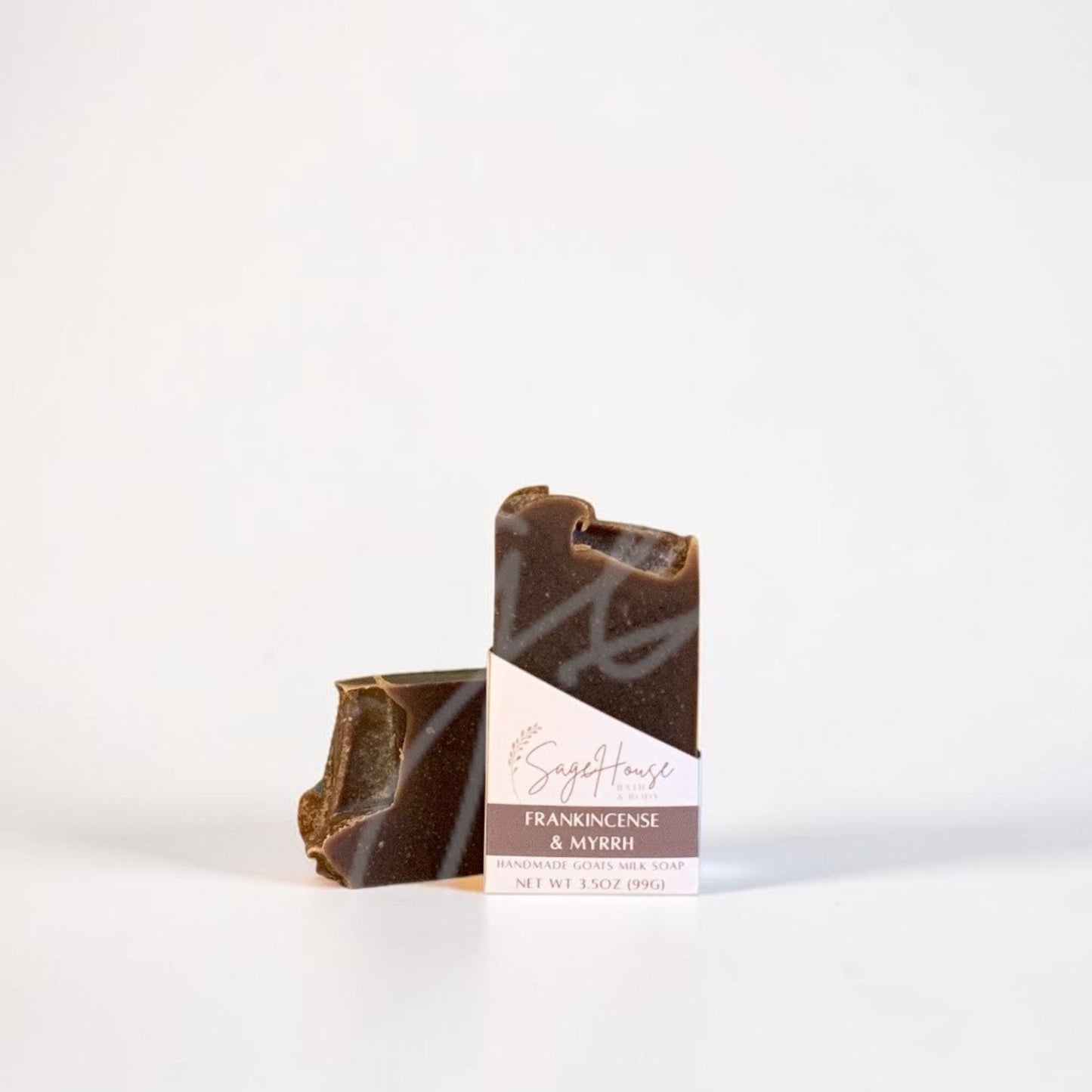 A labeled bar of soap sitting in front of a matching bar of soap. On a white background.