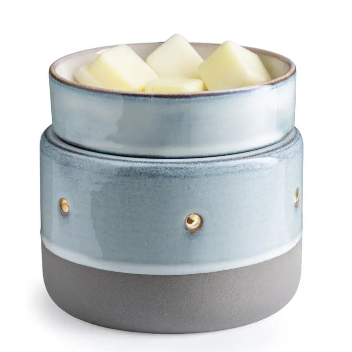 A concrete finish on a ceramic fragrance warmer with a blue and gray color scheme, featuring a lid and a dish with wax cubes on top.