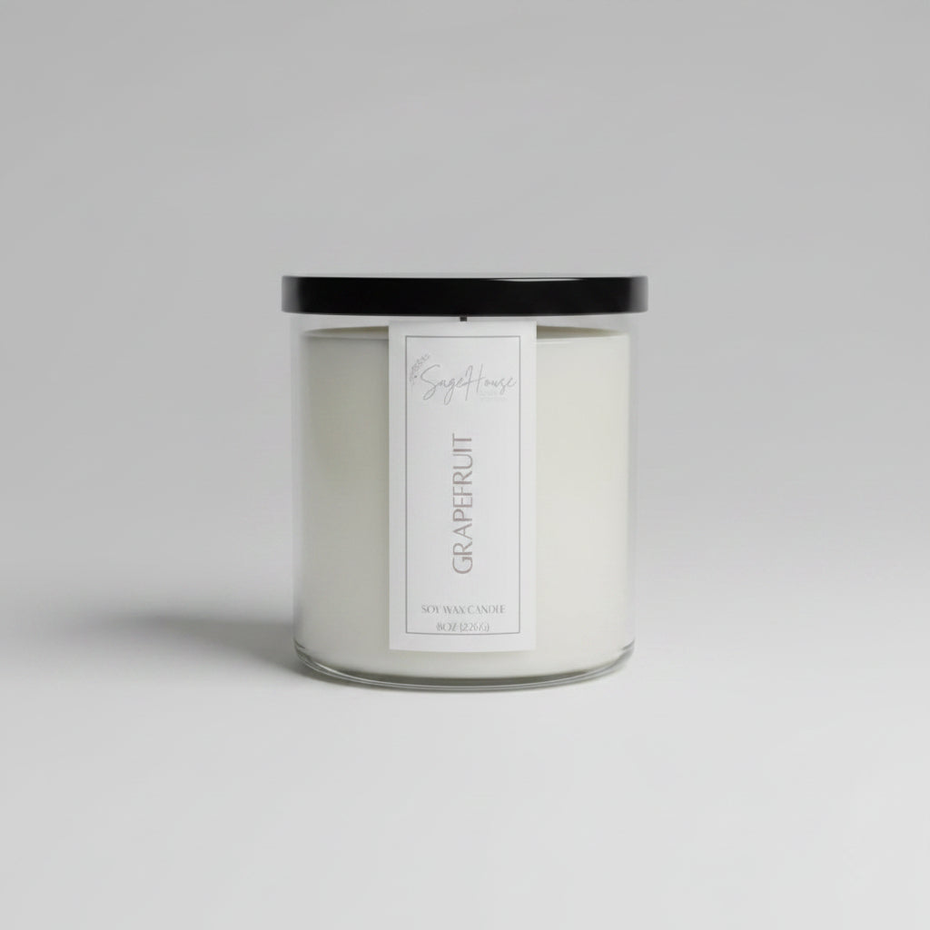 A white soy wax candle in a clear container, placed on a neutral background.