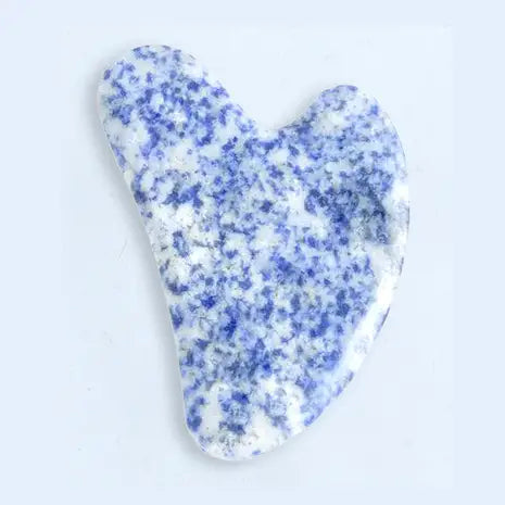 Blue and white speckled gua sha tool on a white background