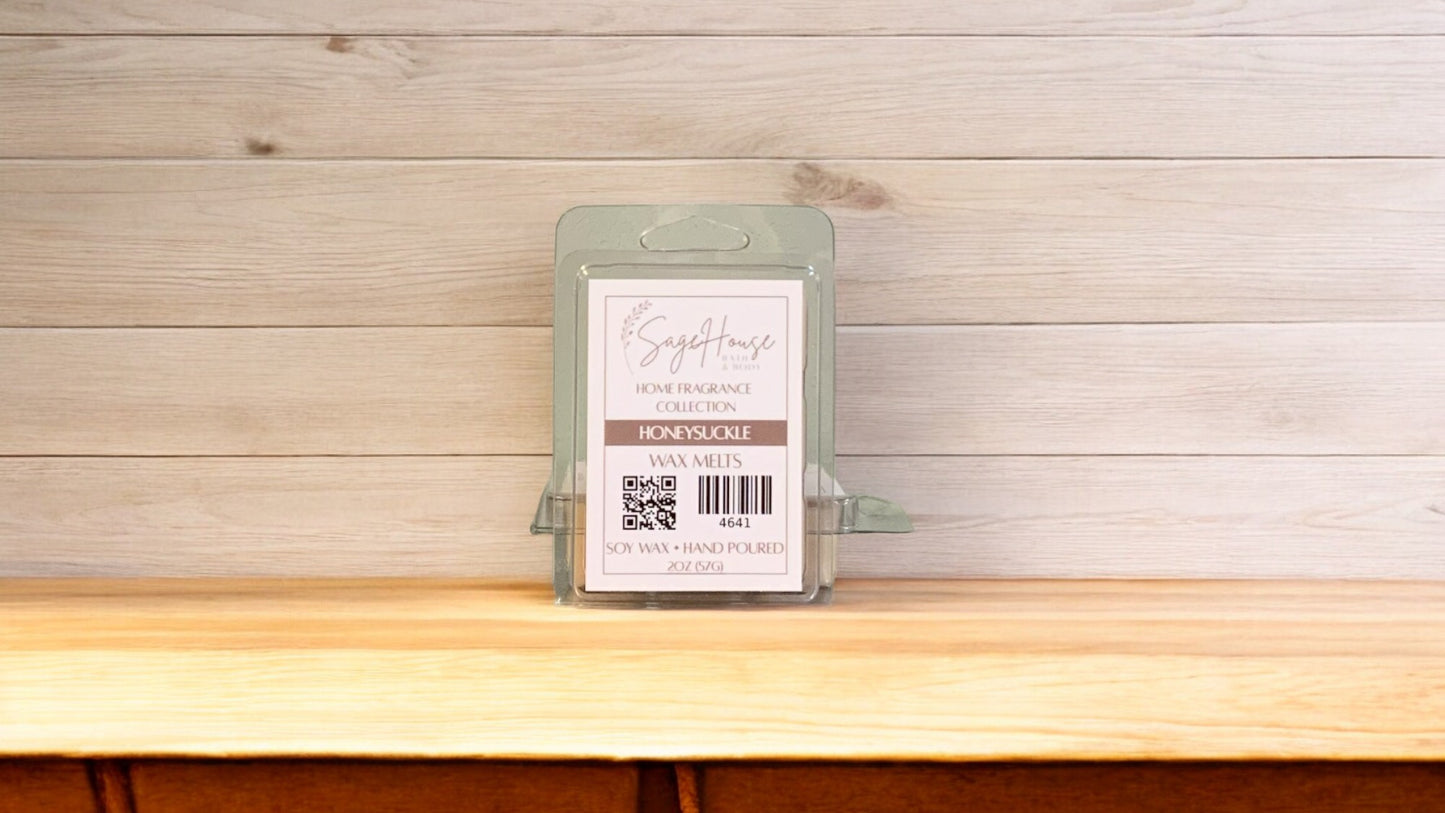 A clear clamshell container holding 6 wax melt cubes with a label on top, placed on a wooden surface against a wooden background.