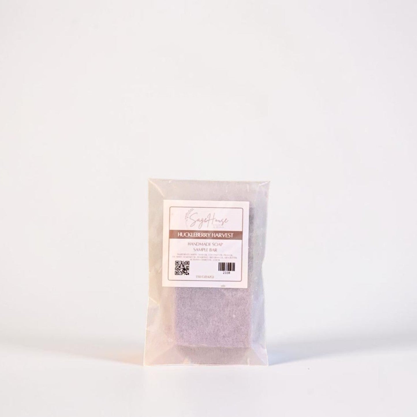 A sample bar of soap in a frosted glassine bag with label. Sitting on a white background.