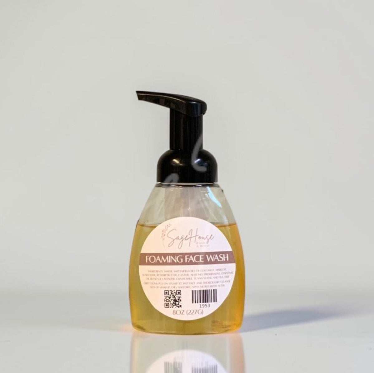 A bottle of liquid soap with a black pump and white label. On a light gray background.
