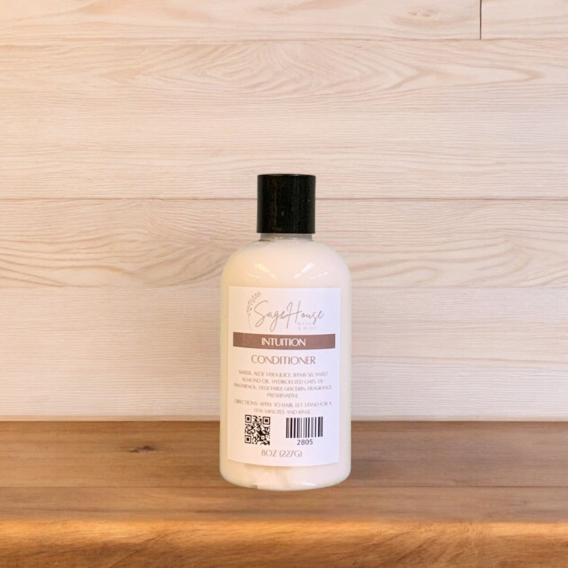 A bottle of Intuition conditioner in a clear bottle on a wooden surface.