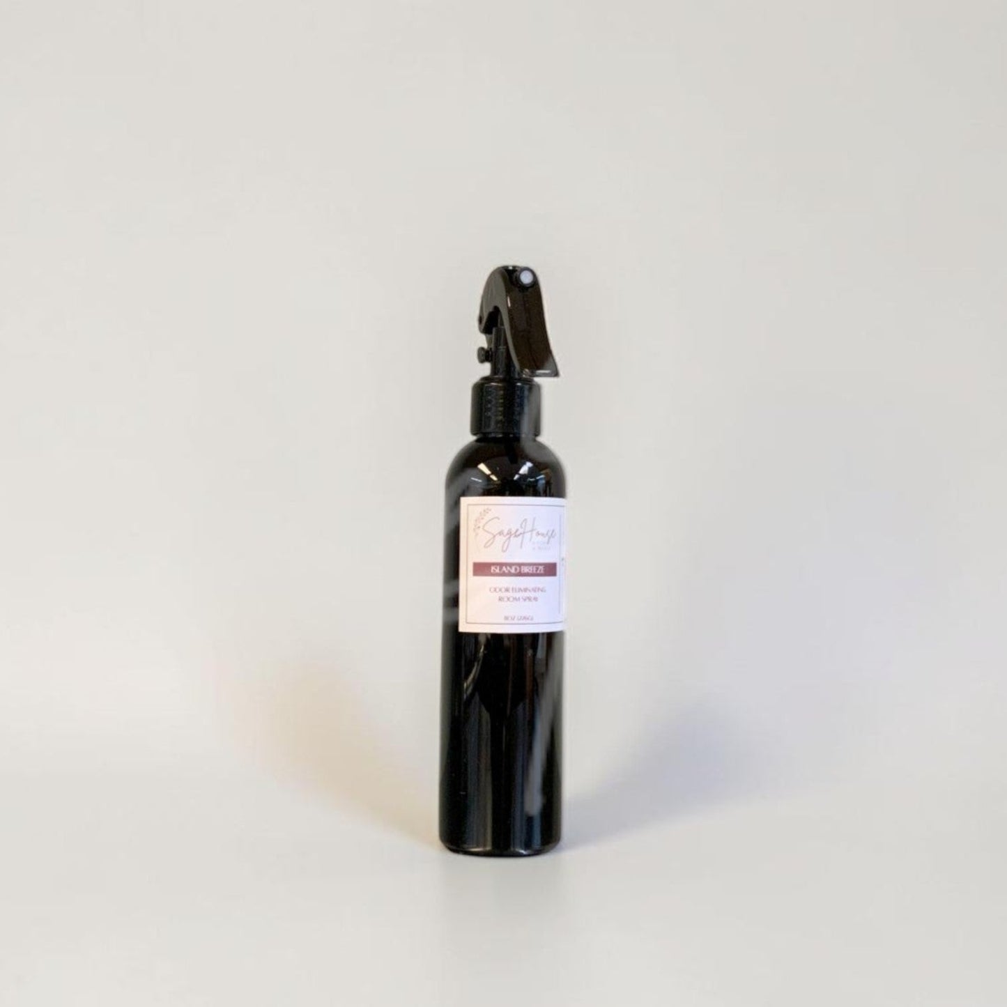 Black spray bottle with a label on a gray background