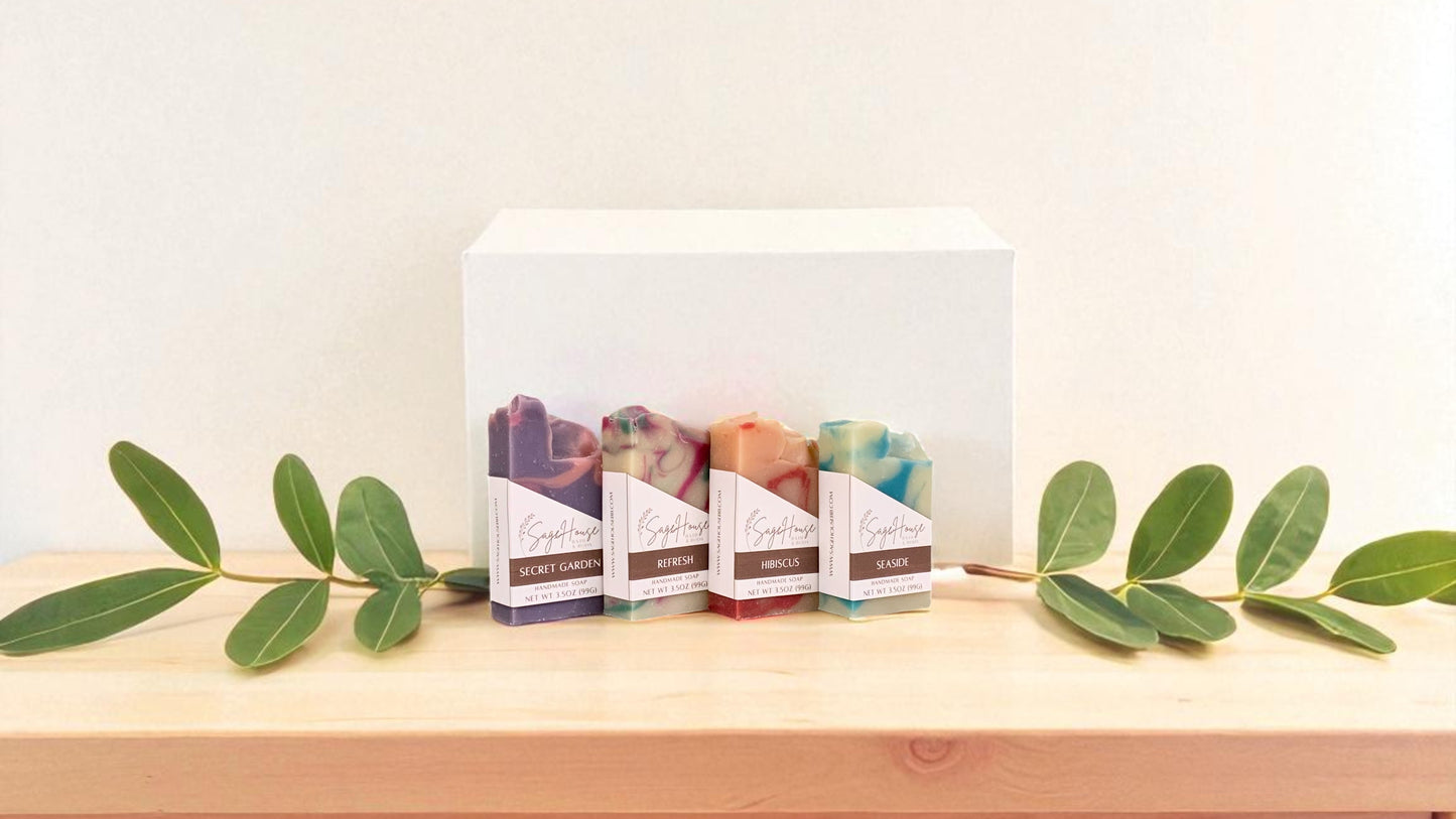 Set of soap bars with packaging on a wooden surface with green leaves