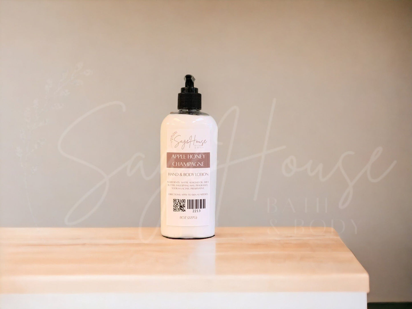 A large bottle of lotion with a black pump top. Sitting on a white countertop with neutral background