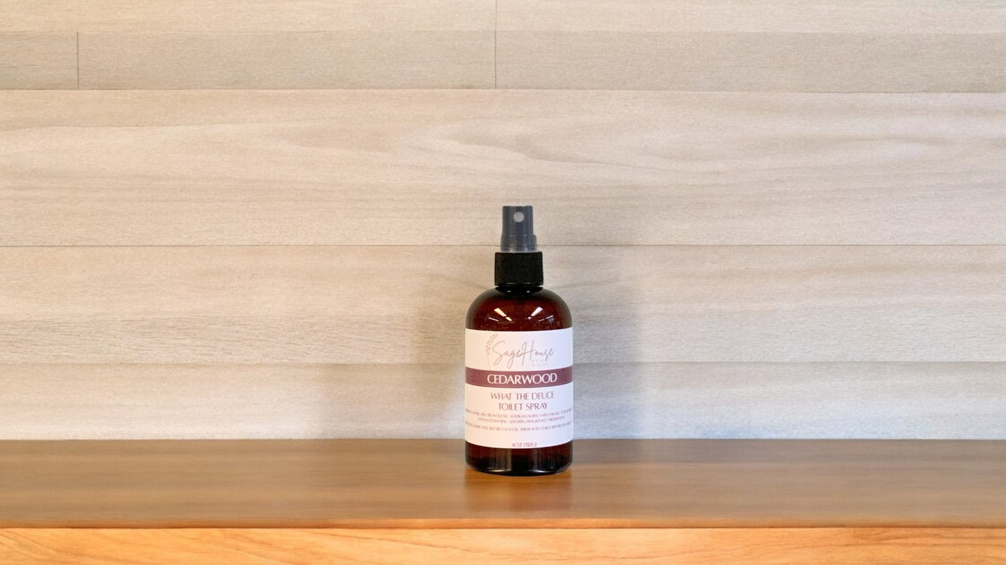 Amber colored spritz bottle with cedarwood label, on wood surface