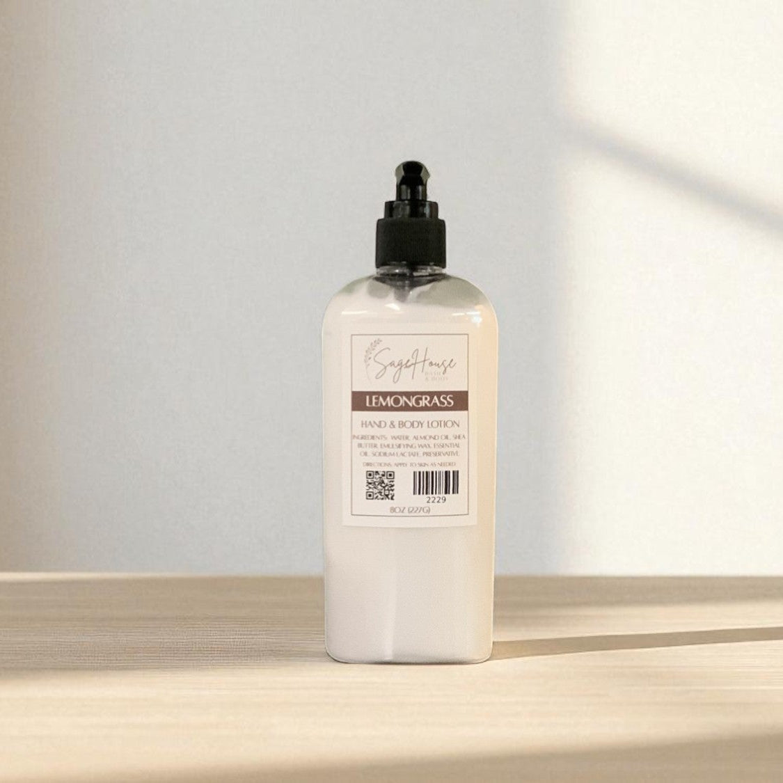 White bottle of lotion with black pump top on a light wooden surface with a blurred white background