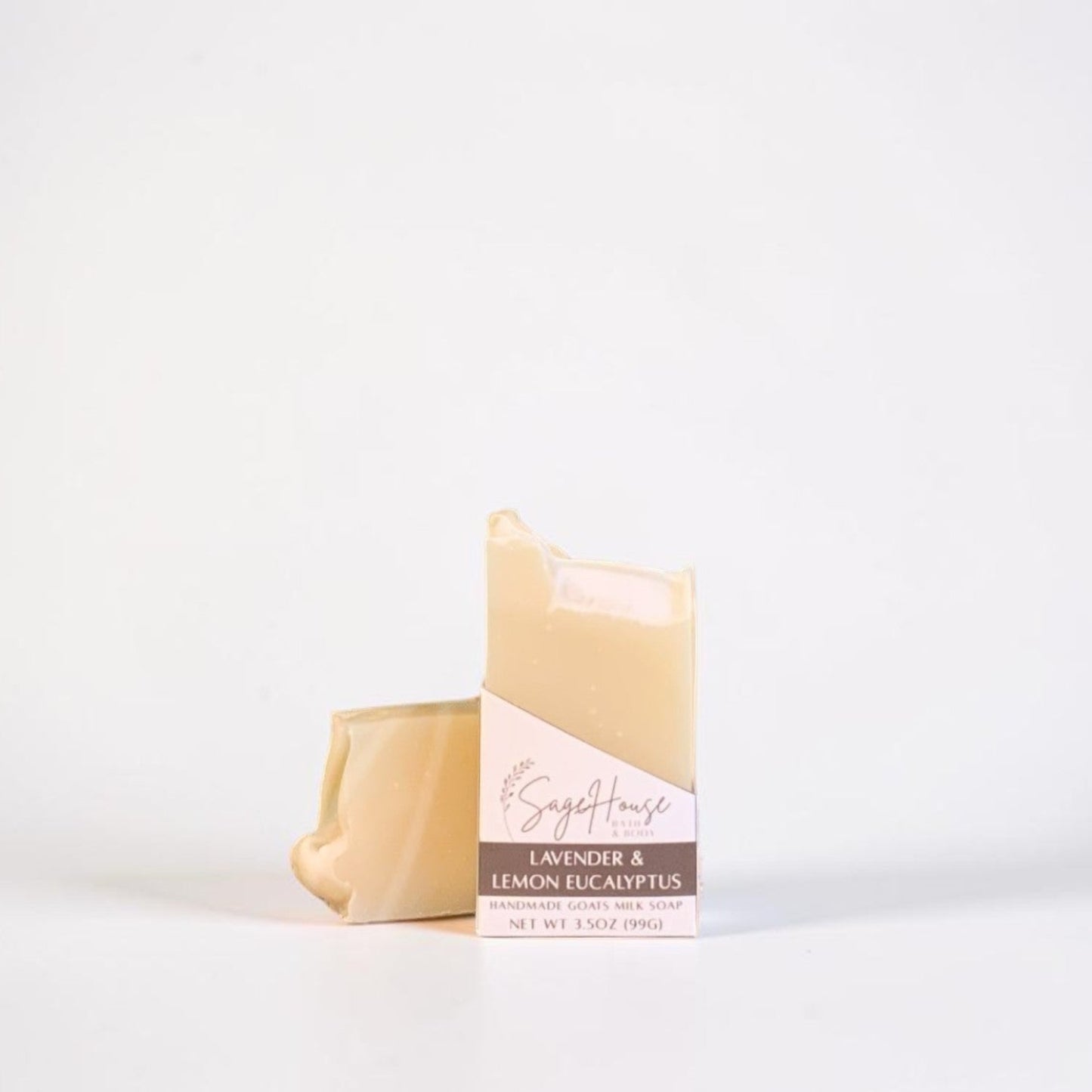 A labeled bar of soap sitting in front of a matching bar of soap. On a white background.