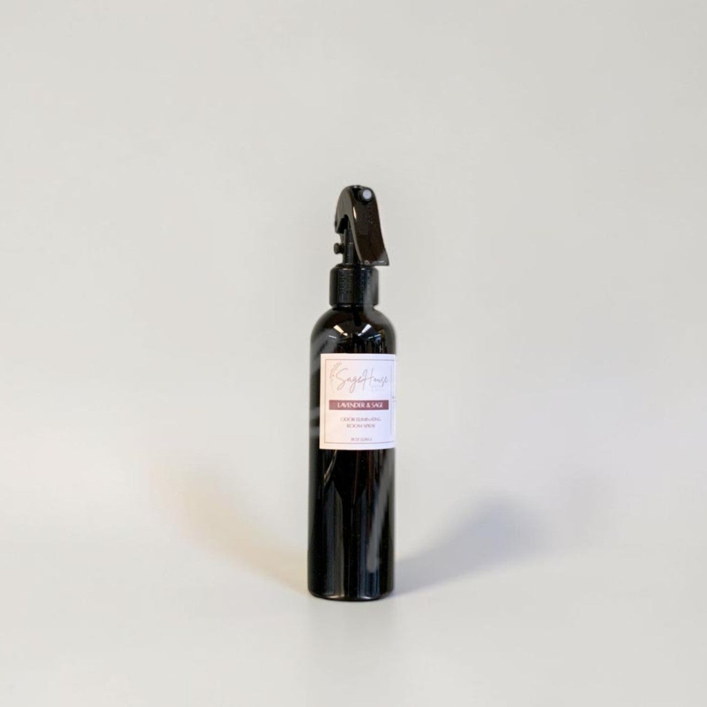 Black spray bottle with a label on a gray background