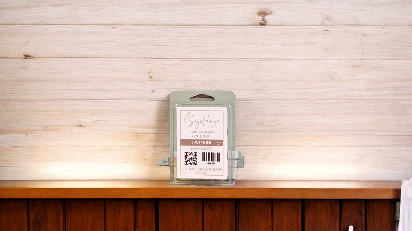 A clear clamshell container holding 6 wax melt cubes with a label on top, placed on a wooden surface against a wooden background.