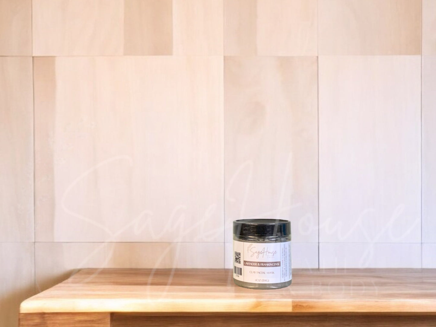 A face mask product in a small container, with a beige background resembling a wooden texture.