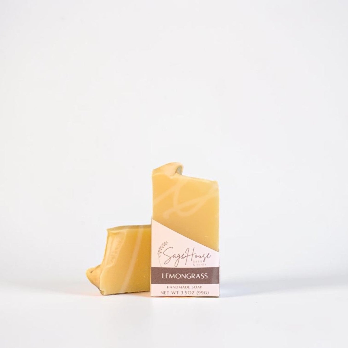 A labeled bar of soap sitting in front of a matching bar of soap. On a white background.