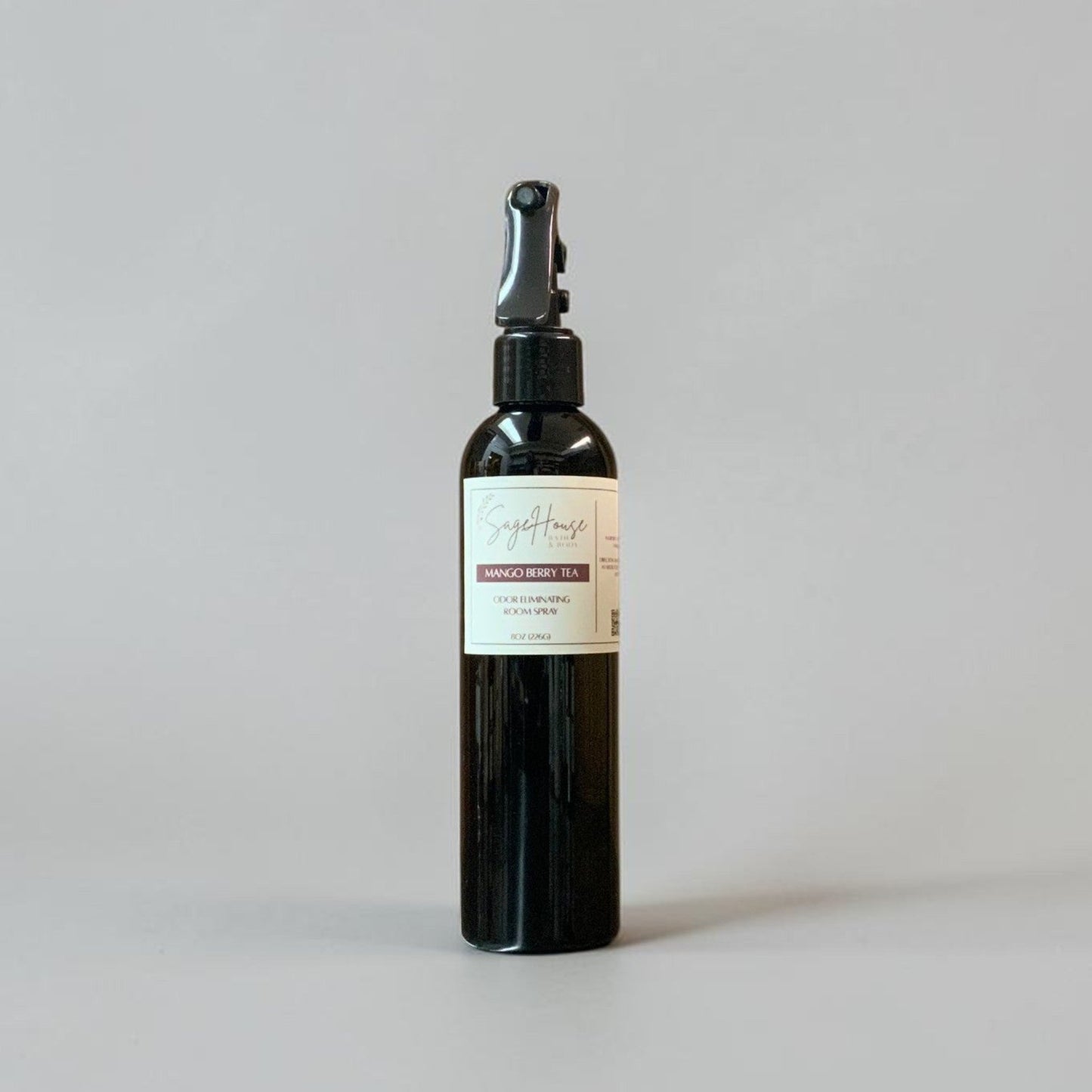 Black spray bottle with a label on a gray background
