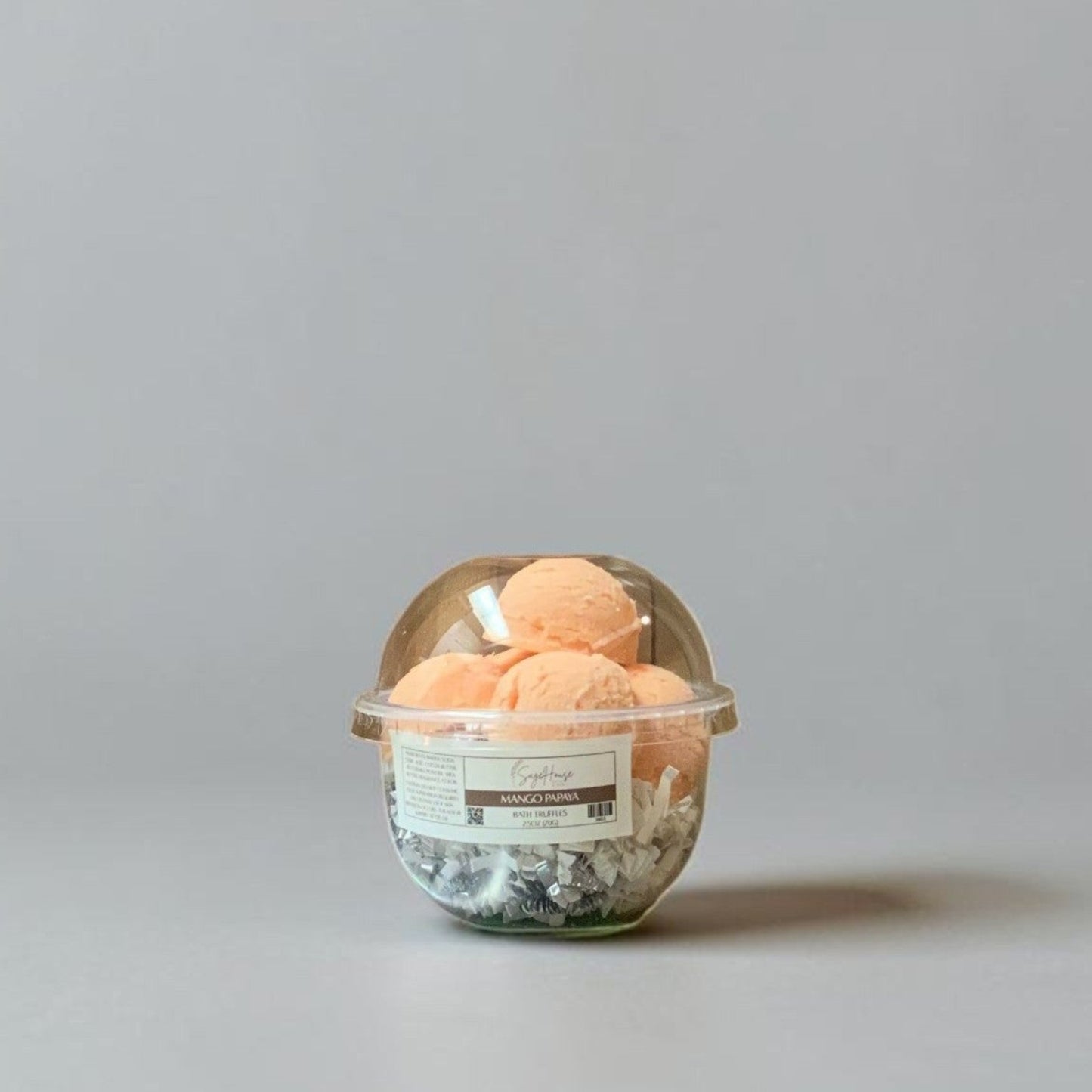 a container of bath truffles on a grey background.