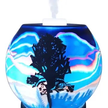 A decorative ultrasonic diffuser featuring a tree silhouette against a blue background with a Northern Lights pattern.