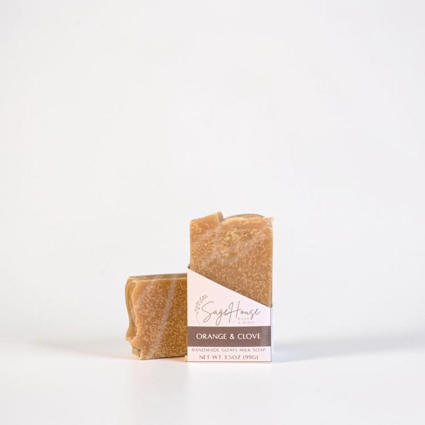 A labeled bar of soap sitting in front of a matching bar of soap. On a white background.