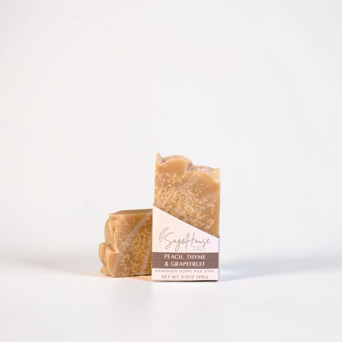 A labeled bar of soap sitting in front of a matching bar of soap. On a white background.
