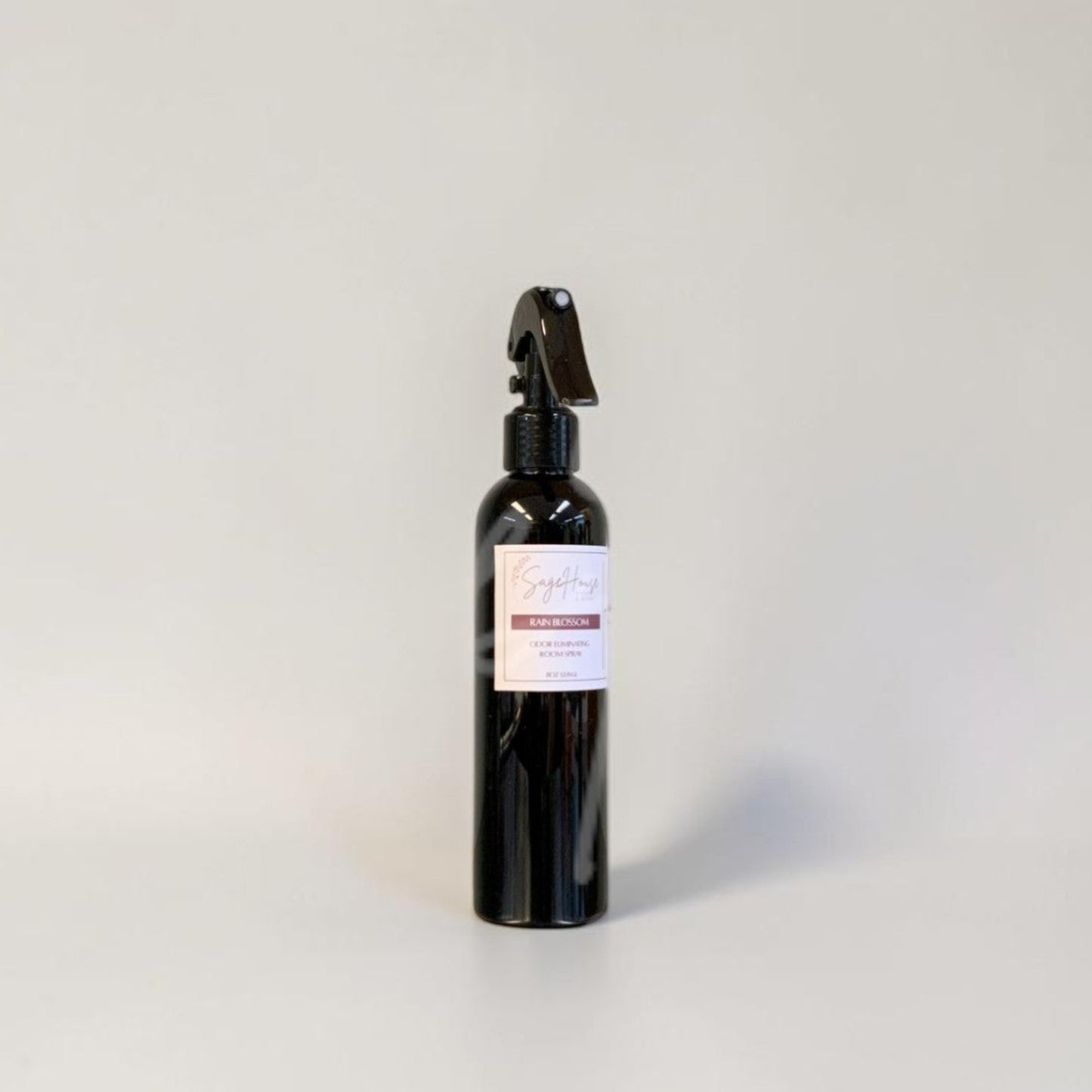 Black spray bottle with a label on a gray background