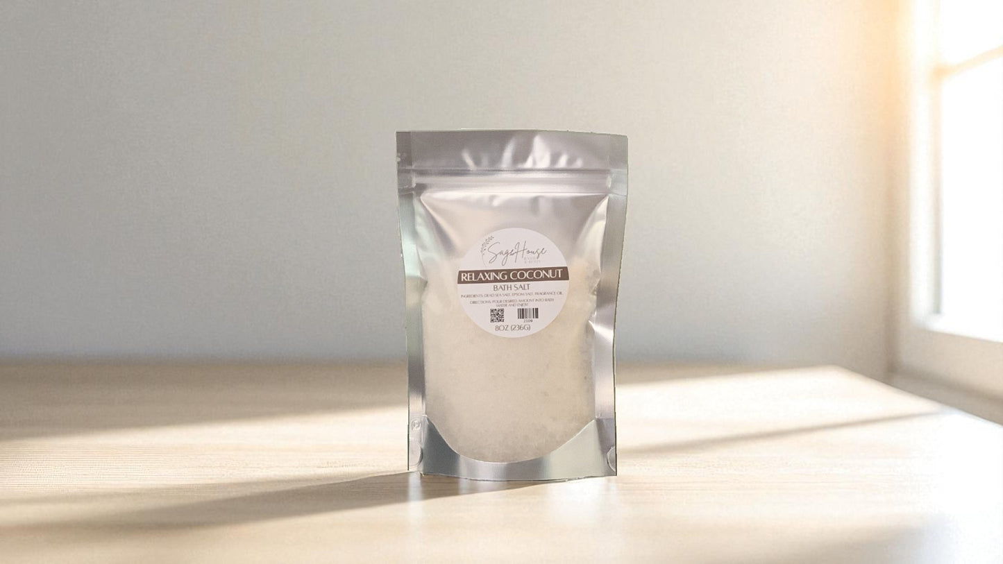 Silver packaging with a clear window of white salt labeled "relaxing coconut" on a wood surface.
