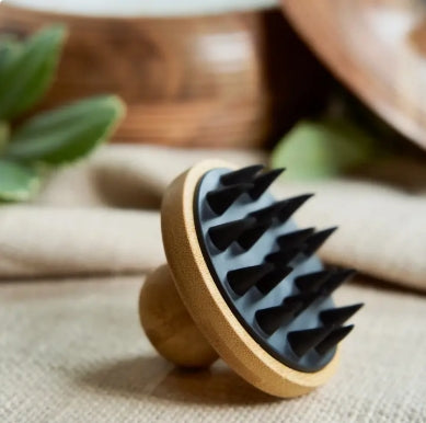 Wooden brush with rubber black bristles on a textured surface with blurred background