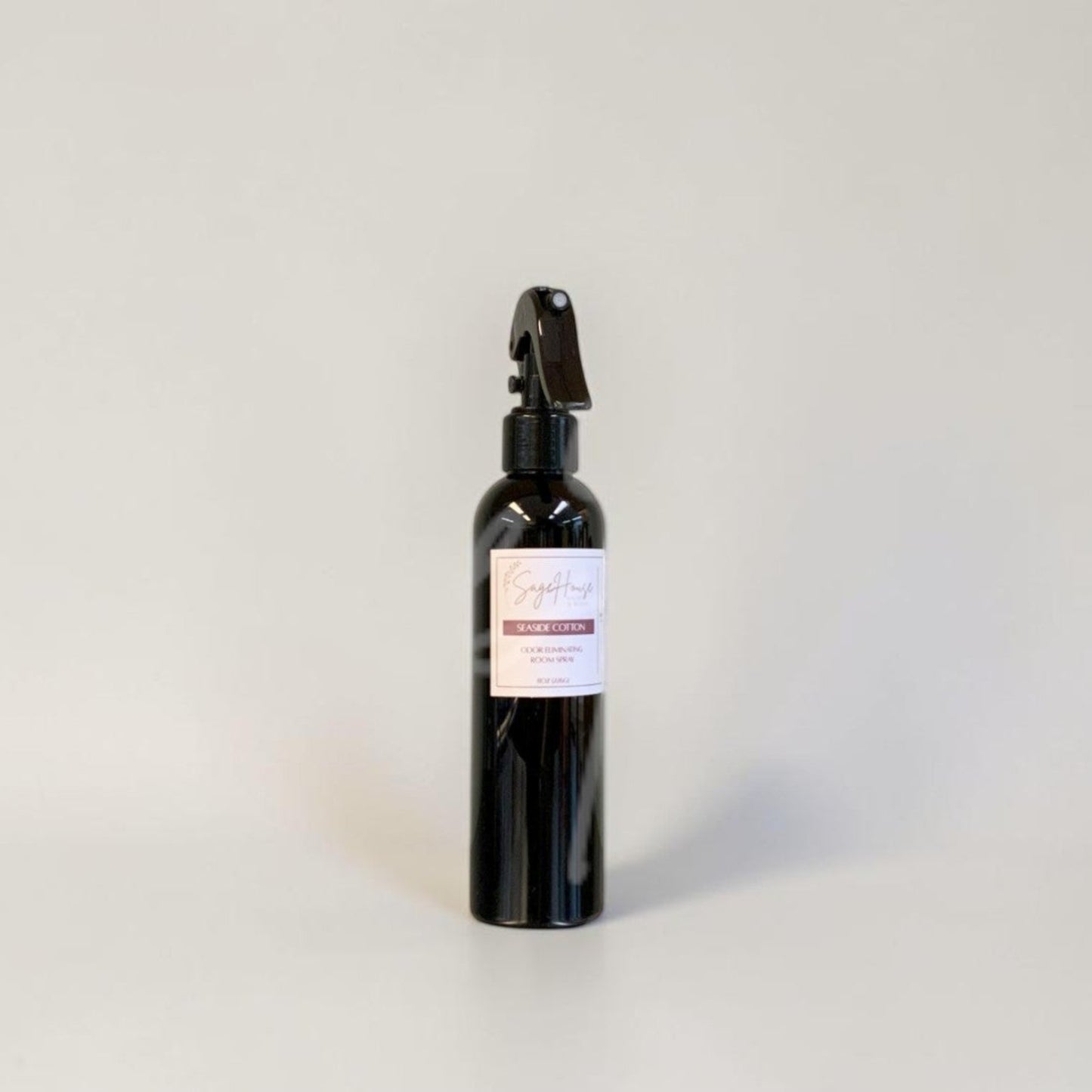 Black spray bottle with a label on a gray background