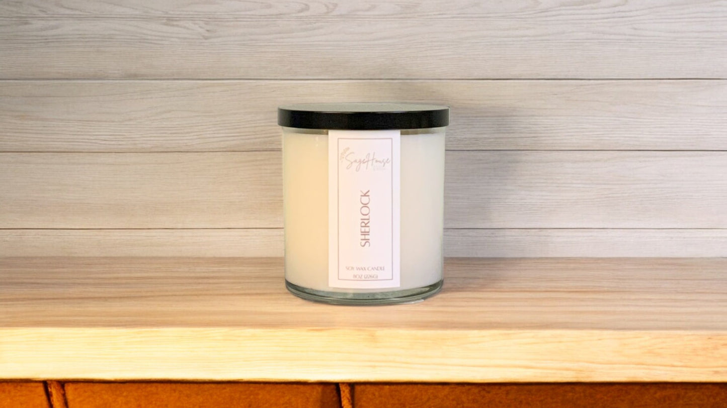 A white soy wax candle in a clear container, placed on a wooden surface, with a label on the front.