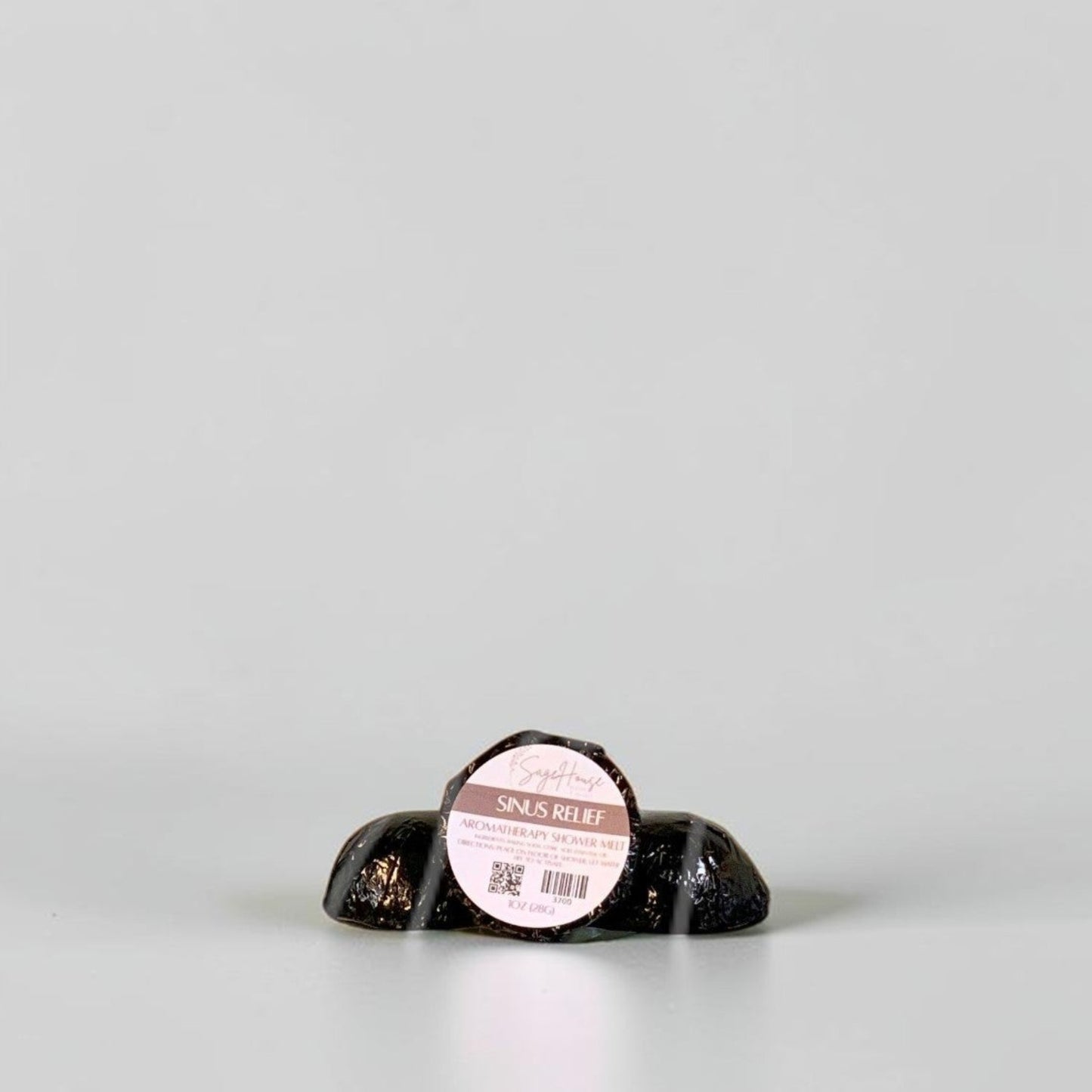 One labeled shower melt propped in front of 2 other shower melts. Sitting on a white background.