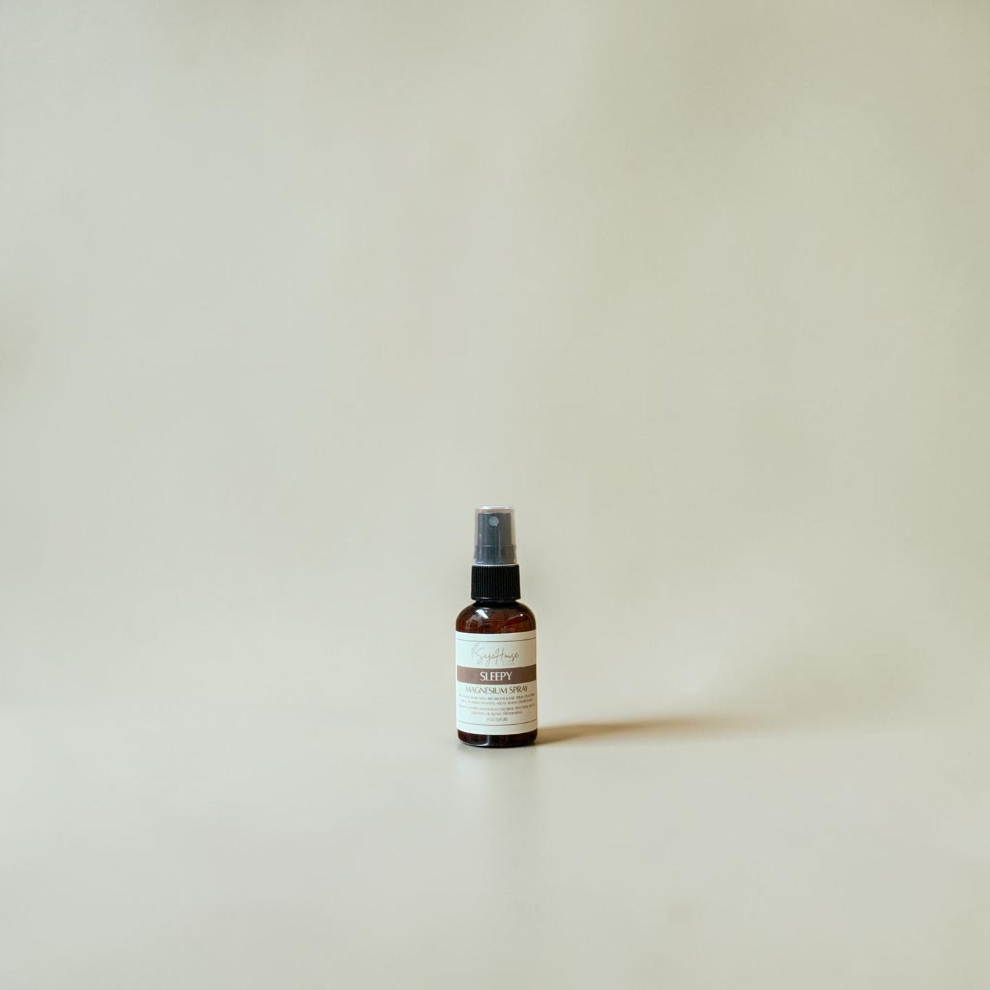 Small spray bottle with a label on a plain background