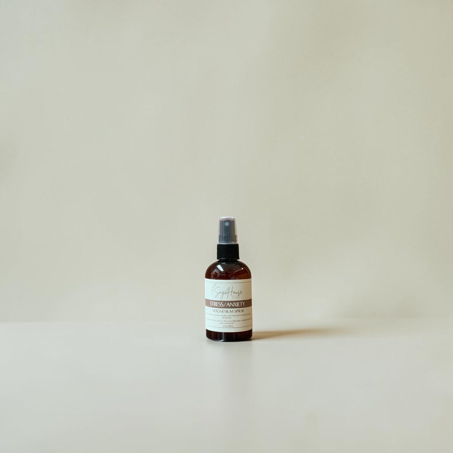 Small brown spray bottle with a label on a light beige background