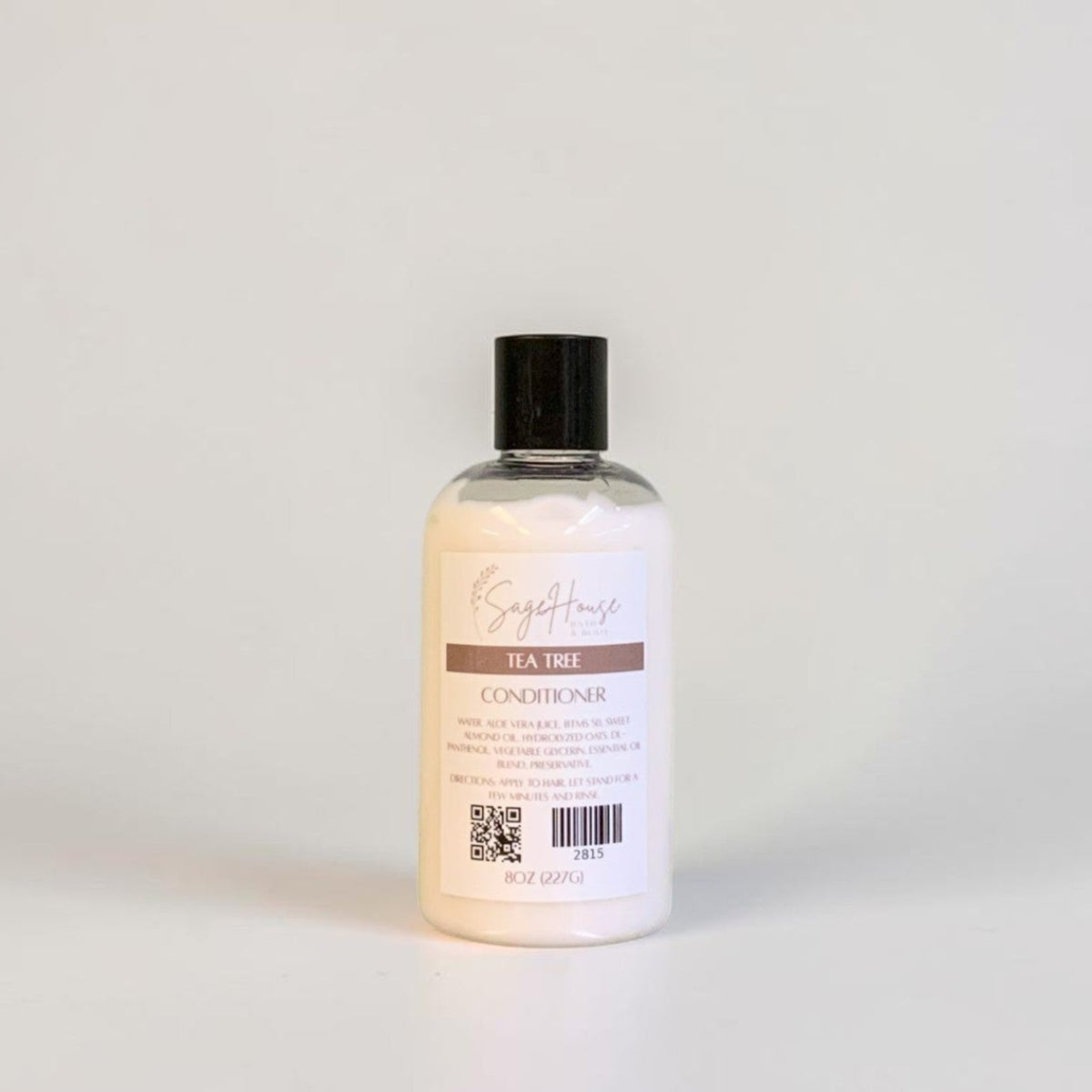 A bottle of conditioner with a black cap and white label. On a white background.