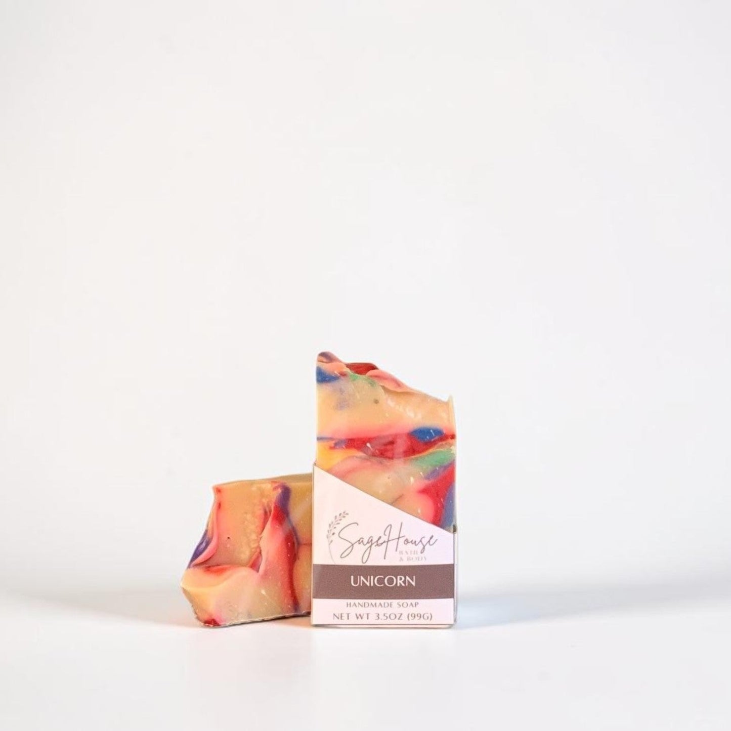 A labeled bar of soap sitting in front of a matching bar of soap. On a white background.