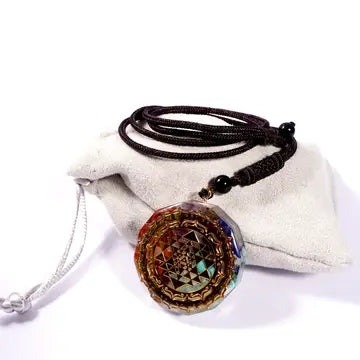 A multicolored geometric-patterned chakra pendant necklace with a resin centerpiece, adorned with a black rope chain.