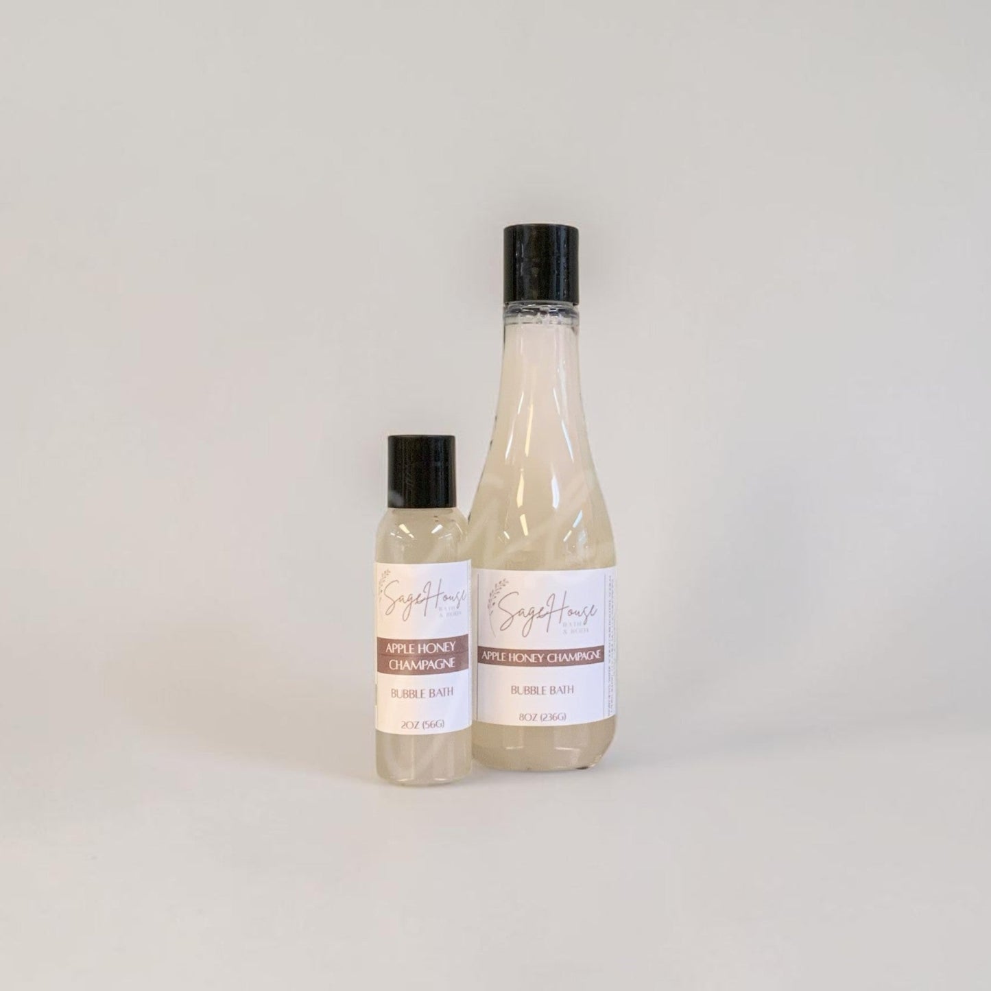 Two bottles of bubble bath on a light gray background