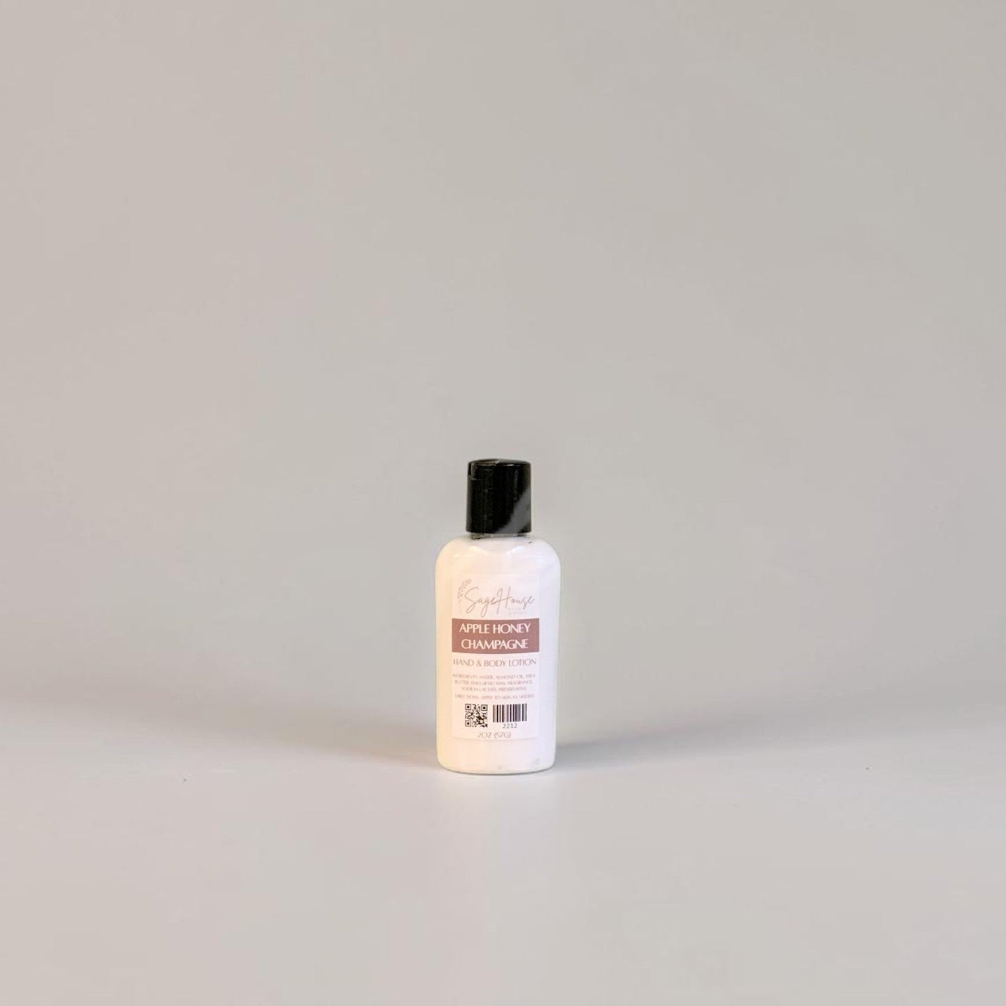 A small bottle of lotion with black cap and white label. On a white background.